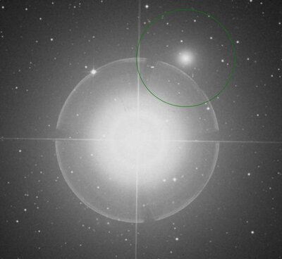DSS2 image of NGC 404 in the Red band. The green region on the image is a representation of the major (3.4 arcmin) and minor (3.37 arcmin) axes of the object's apparent size.