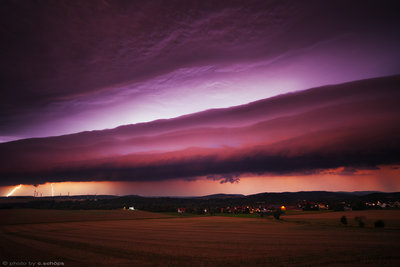 Illuminated Twilight Shelf Cloud<br /><br />A shelf cloud is a laminar gust front of a thunderstorm. The gust front occurs when downward winds hit the ground and cold pool is sidelining into the moist, still warmer air mass in front of the storm pushing a new updraft. Horizontal flow pattern and drier air in higher levels (elevated mixed layer) in the storm environment create this typical layered look. The storm produced plastic, illuminating lightning that makes structures even more visible at late night hours while early dawn adds little more color to the whole photogenic atmosphere.