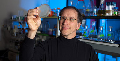 Michael Hecht, a professor of chemistry at Princeton University, has led a team of researchers who have for the first time constructed artificial proteins that enable the growth of living cells. The synthetic proteins were designed from scratch and expressed from artificial genes. He is holding samples of living bacteria containing the synthetic proteins. Photo by: Brian Wilson