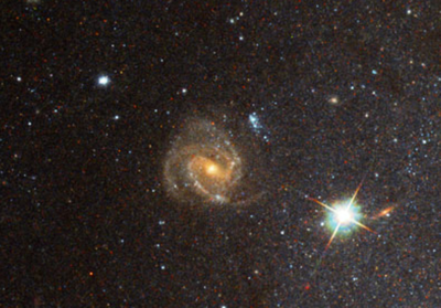 Closeup of 3 armed background galaxy in M101.png